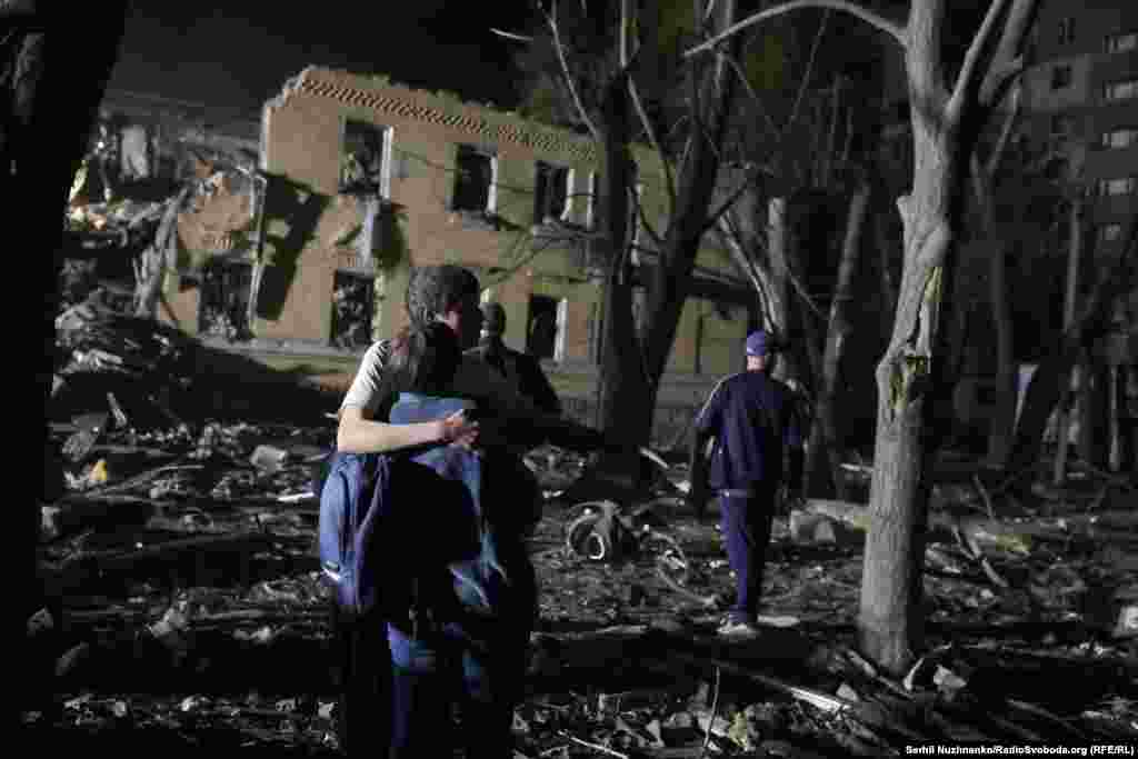 Люди дивляться на наслідки обстрілу