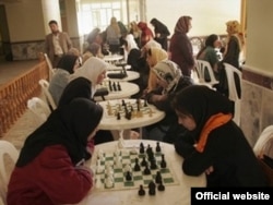 Okuwçy gyzla Herat welaýatynda geçirilen ýaryşda küşt oýnaýarlar. 17-nji maý, 2010-njy ýyl.