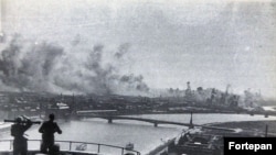 Soldați unguri cu un telemetru privesc de pe Dealul Gellert un bombardment american în Budapesta ocupată de naziști în 1944.