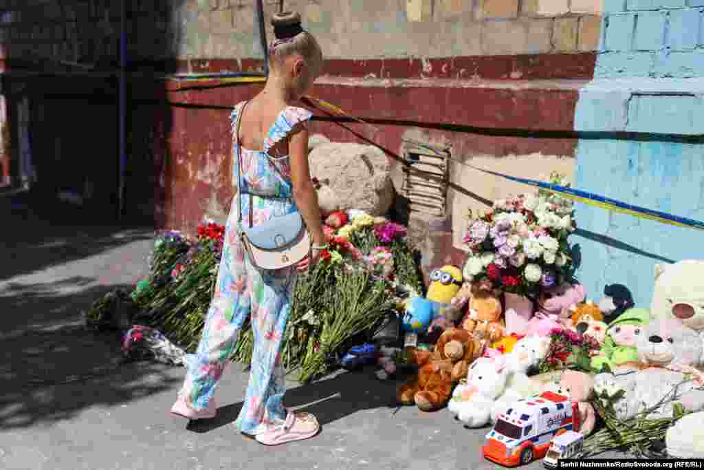 Діти несуть квіти та іграшки до житлової п’ятиповерхівки в Києві, у яку влучила російська ракета. Російська атака забрала життя понад 20 мешканців цього будинку, зокрема чотирьох дітей. Серпень 2025 року