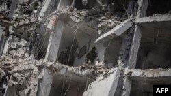 Ізраільскія выратавальныя каманды зь ліхтарыкамі і сабакамі шукаюць людзей у разбураным ад іранскага ўдару жылым доме, 15 чэрвеня 2025 году