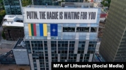 Банер «Путін, Гаага чекає на тебе» поруч із прапорами Литви, України та НАТО, Вільнюс, Литва, 21 серпня 2024 року