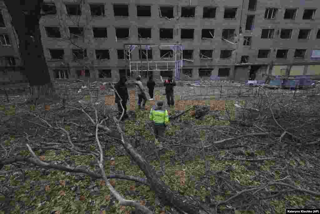 Працівники міста стоять у вирві від російського КАБу, який впав на подвір'я житлової забудови у Запоріжжі, 11 листопада 2024 року
