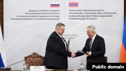 Armenia - Deputy Prime Minister Mher Grigorian (right) and his Russian counterpart Alexei Overchuk sign documents after chairing a meeting in Yerevan, December 17, 2025.