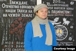 Елена Попова на фоне антивоенных плакатов петербургской художницы Елены Осиповой