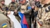 Militari ucraineni distrug steagul rusesc după ce au recucerit un sat din regiunea Harkov, Ucraina, 13 septembrie 2022.