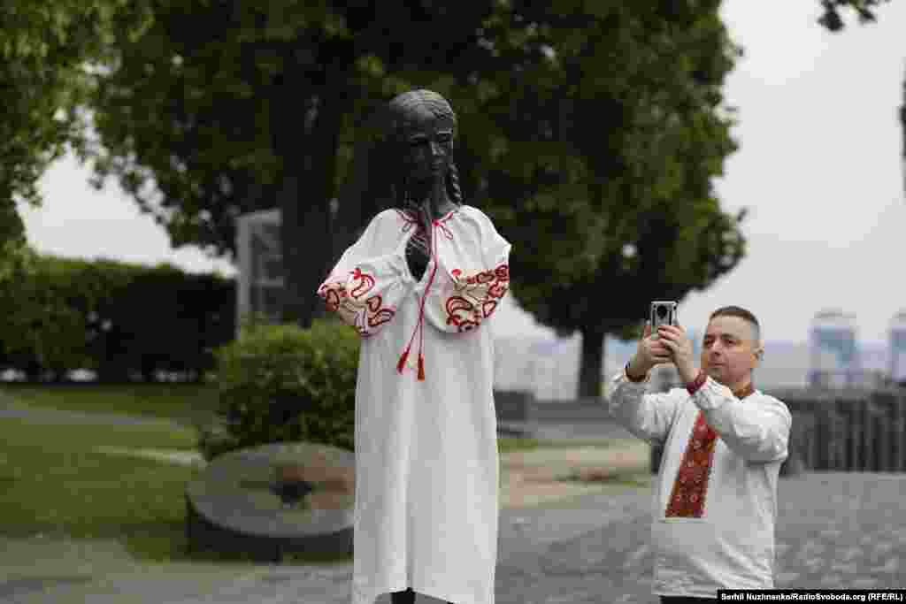 Дівчинка із колосками біля Музею Голодомору у вишитій сорочці. «Цією символічною акцією ми нагадуємо про те, що попри Голодомор, депортації, репресії ми вижили і зберегли свою ідентичність. І саме вишиті сорочки наших бабусь і прабабусь, обміняні на пригорщу зерна, колись врятували не одне життя», – повідомили у музеї