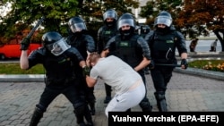 Belarus milisiýasy bir demonstranty saklaýar. Minsk, 10-njy awgust, 2020 ý.
