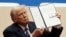 Дональд Трамп демонстрирует один из указов, подписанных им после инаугурационных торжеств 20 января