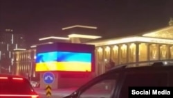 Владимир Путин Астанага келгенде экрандан Украинанын желеги көрсөтүлгөн учур. Соцтармактагы тасмадан алынган скриншот.