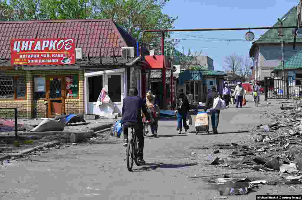 Ринок залишається центром життя – люди збираються там кожного дня, попри небезпеку. Тут торгують речами та їжею, та запитують одне в одного про новини – ані зв’язку, ані енергопостачання в місті зараз немає