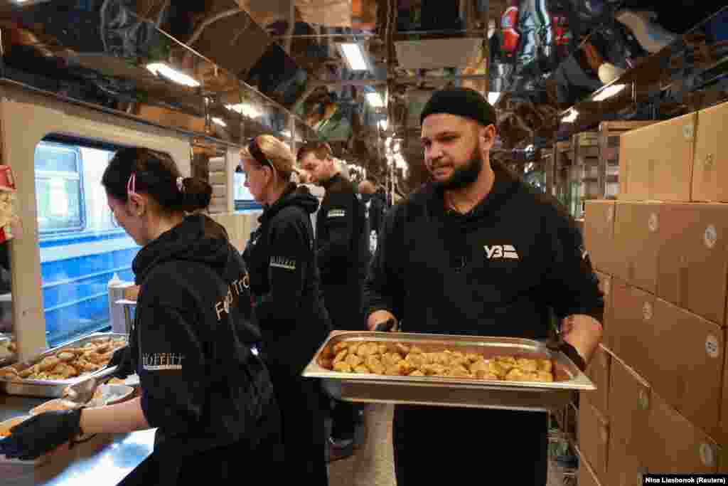 Работники "поезда-кухни" готовят обеденные наборы для жителей Одессы, оставшихся без электроэнергии после недавних российских атак, 16 декабря 2025 года.