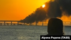 Пожар на Керченском мосту на рассвете после его подрыва, 8 октября 2022 года