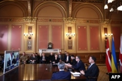 Премьер-министр Великобритании вместе с президентом Украины, генсекретарем НАТО, премьером Дании и премьером Нидерландов перед экраном. Заседание «Коалиции желающих» в гибридном формате. Лондон, Великобритания, 24 октября 2025 года