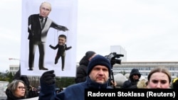 Плакат із зображенням керівника РФ Володимира Путіна (ліворуч) і прем’єр-міністра Словаччини Роберта Фіцо (праворуч) на мітингу протесту в Братиславі, 23 грудня 2024 року